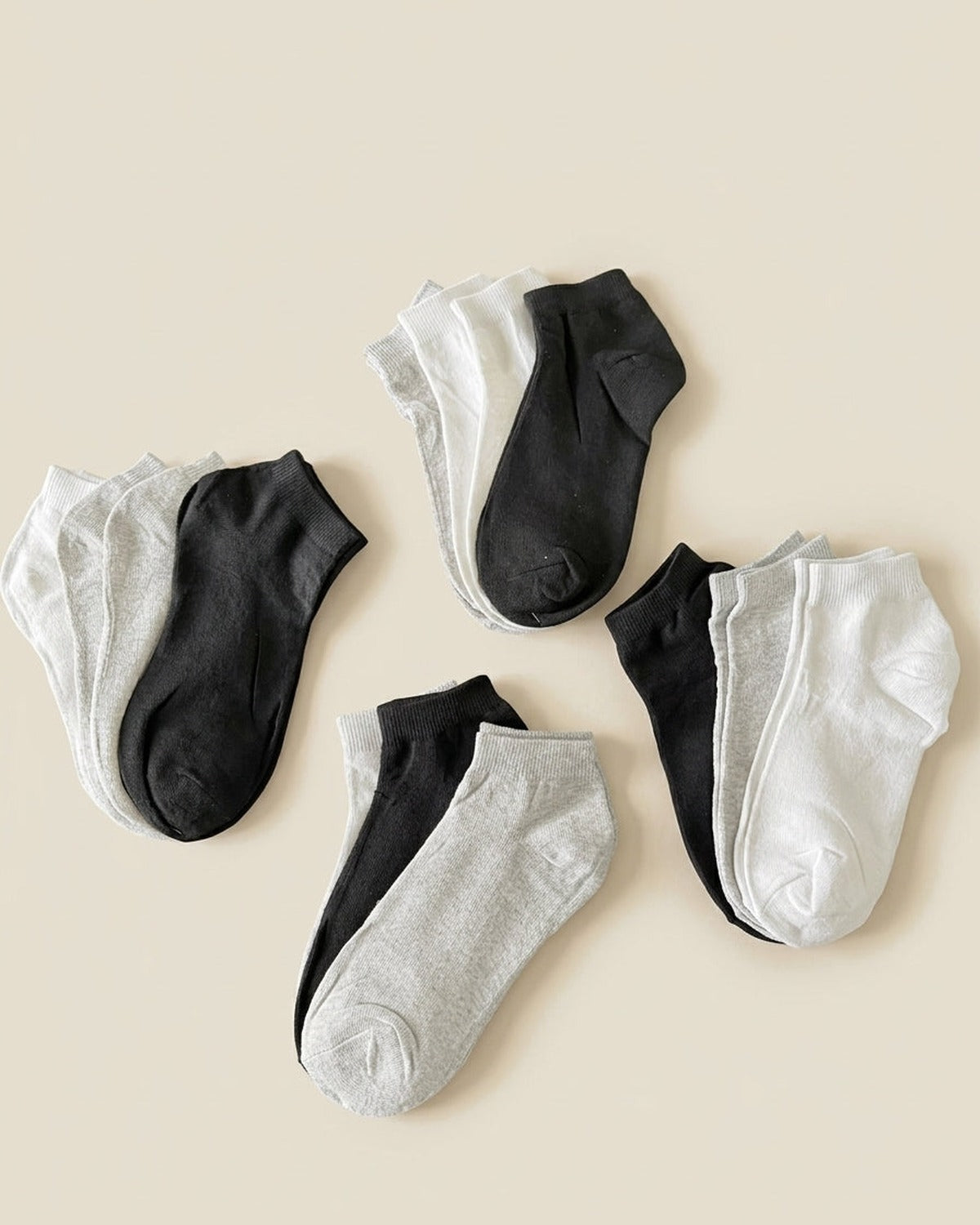 Medias soquete Modo.Basicos: pack de 12 pares surtidos en blanco, gris y negro sobre fondo crema